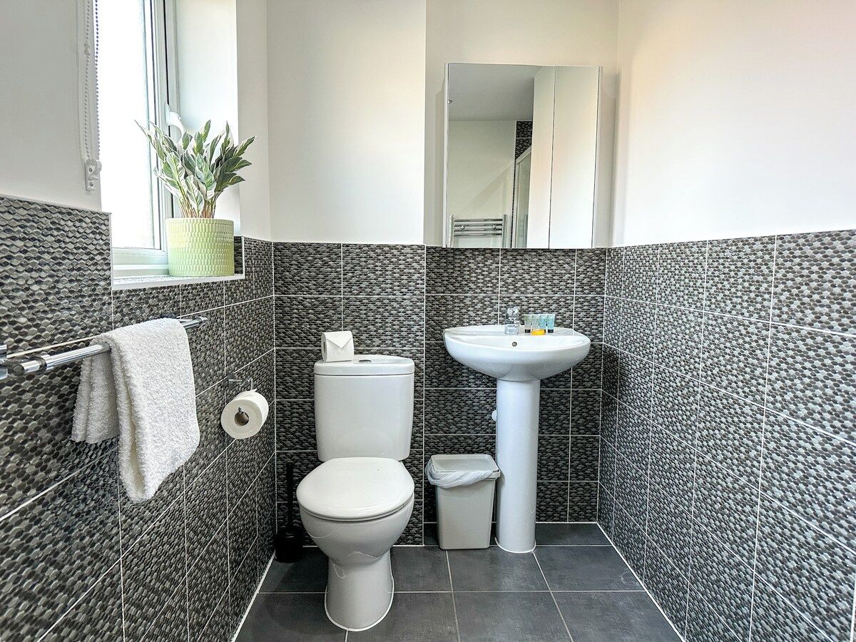 A bathroom with a toilet, sink, and a towel rack.