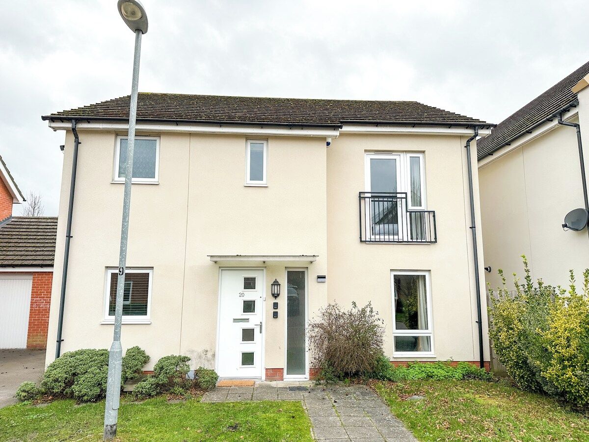A two-story residential building with a flat roof, a front door, and a small balcony.