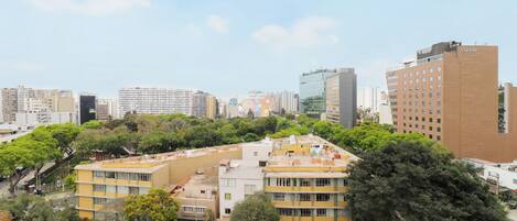 A high-rise hotel with multiple floors, surrounded by other buildings and greenery.