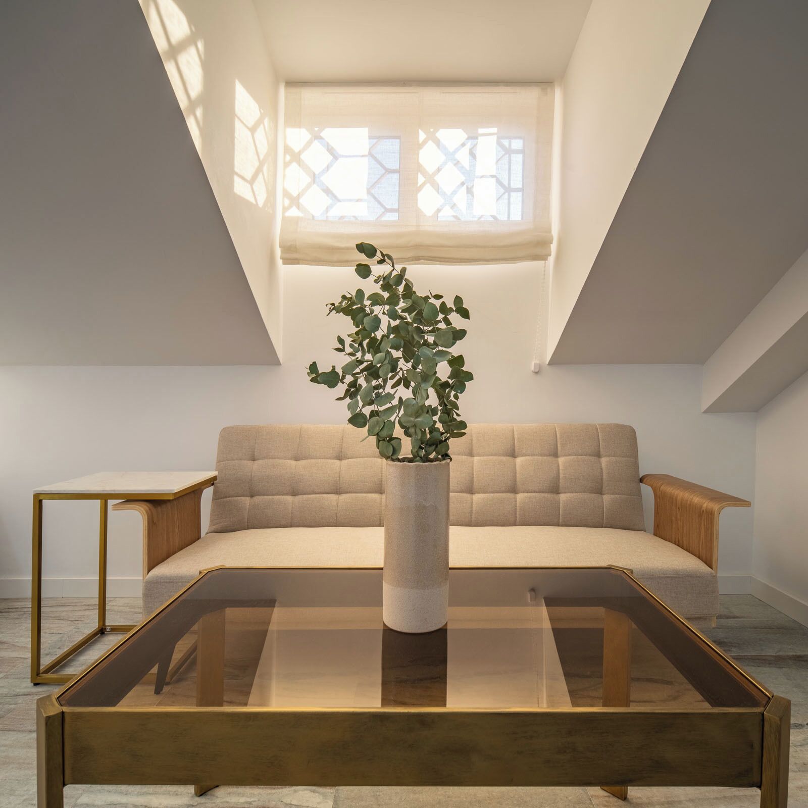 Un salon moderne avec un canapé, une table basse et une plante en pot.
