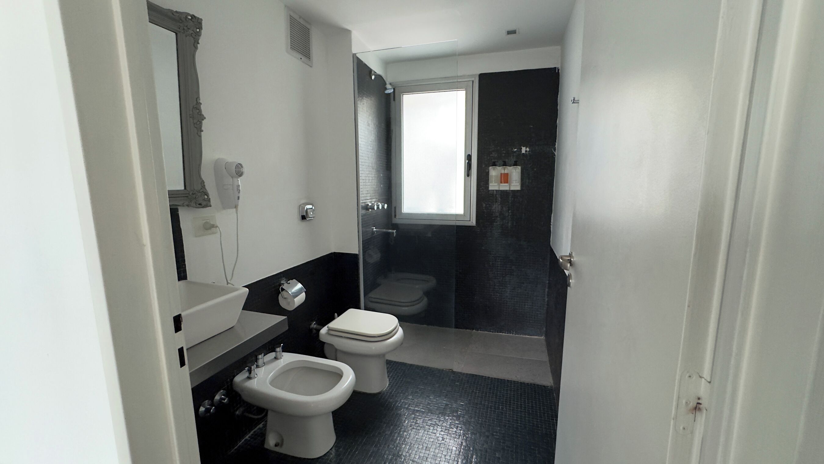 A bathroom with a toilet, bidet, and a shower area.
