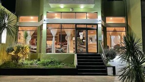 A two-story building with a central entrance, large windows, and a staircase leading to the entrance. - Gran Bahía Resort (San Clemente)
