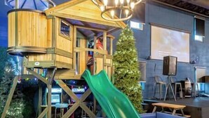A play area with a slide, a wooden playhouse, and a ball pit. - Treehouse & Theater Arcade at Rock Spring Resort (Rock Spring)