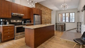 A modern kitchen with wooden cabinets, stainless steel appliances, and a central island.