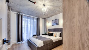 Un dormitorio moderno con una cama grande, cabecera de madera y una araña.