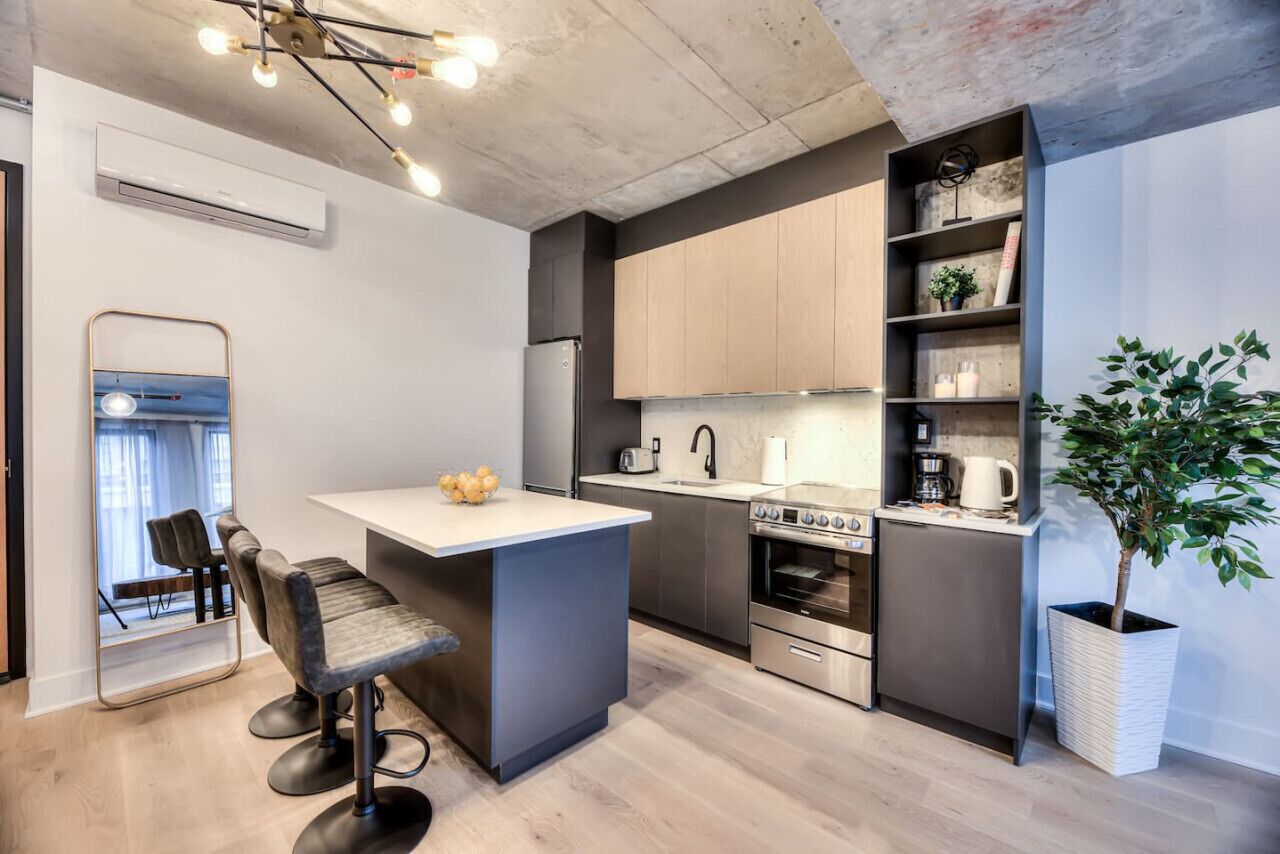 Una cocina moderna con una isla central, electrodomésticos integrados y una zona de bar.