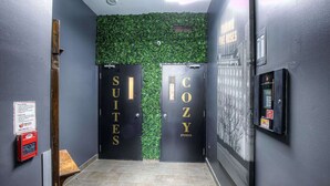 Un couloir avec deux portes indiquant « Suites » et « Petits espaces confortables ».