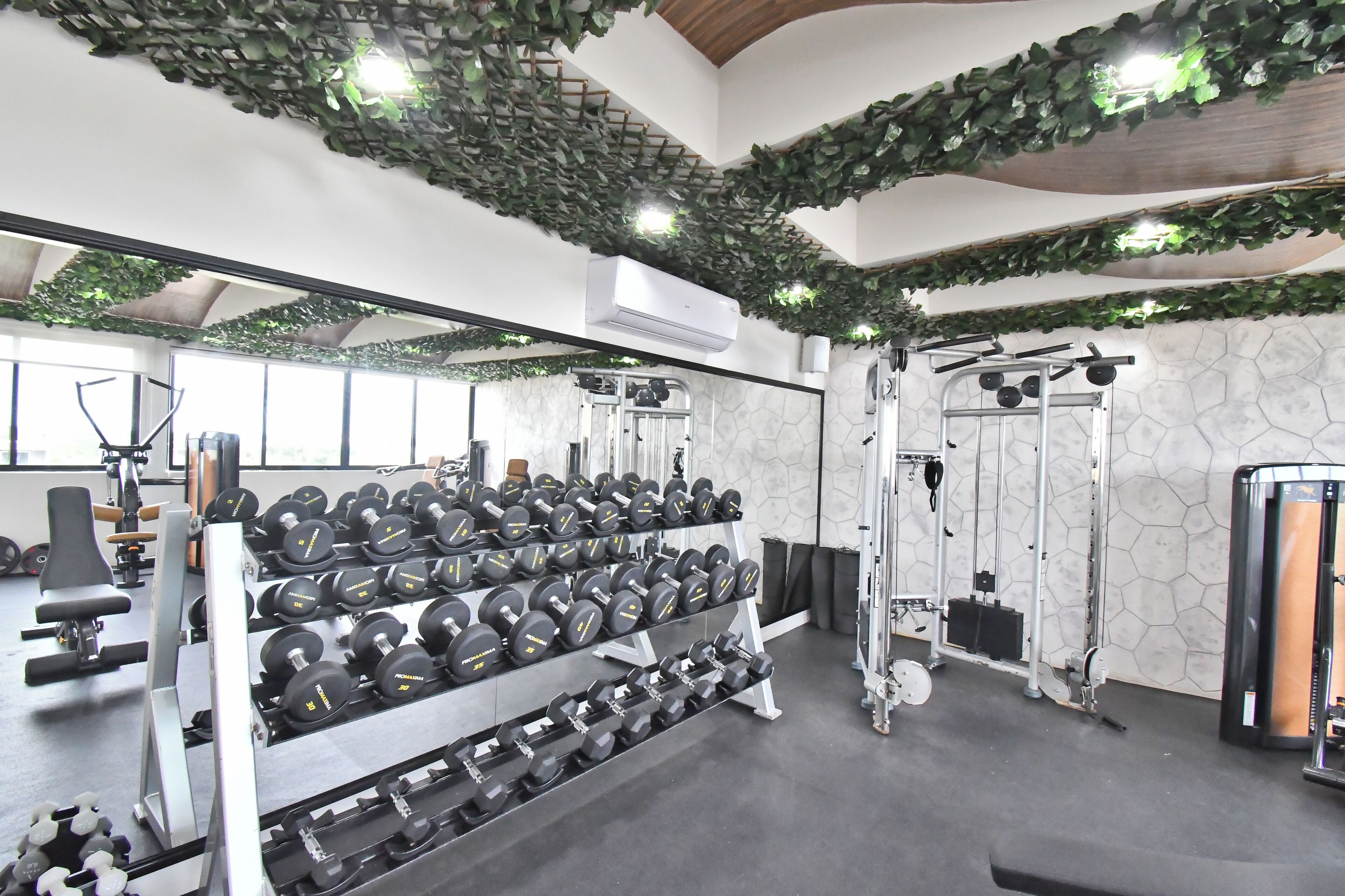 Un gimnasio con jaulas de pesas, mancuernas y máquinas de ejercicio.