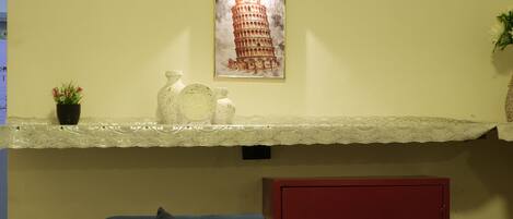 A living room with a sofa, a red cabinet, and a wall-mounted light fixture.