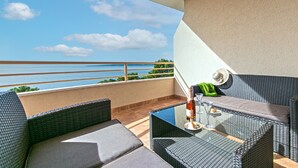 A balcony with wicker furniture, a glass table, and a bottle of wine. - Apartments Relax Brela - Two Bedroom Apartment (Brela)