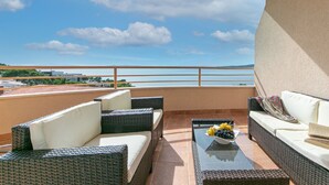 A balcony with wicker furniture, a glass table with fruit, and a view of the sea. - Apartments Relax Brela - Two Bedroom Apartment (Brela)