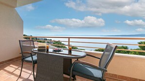 A balcony with a table and chairs, overlooking a scenic view of a body of water and distant mountains. - Apartments Relax Brela - Studio (Brela)