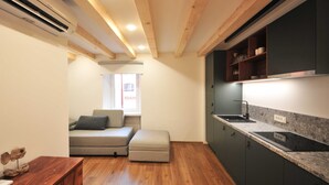 Una cocina compacta con vigas de madera, estufa integrada y ventana con vista a la ciudad.