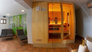 A sauna room with a wooden cabinet, two chairs, a wall mural, and a toilet.