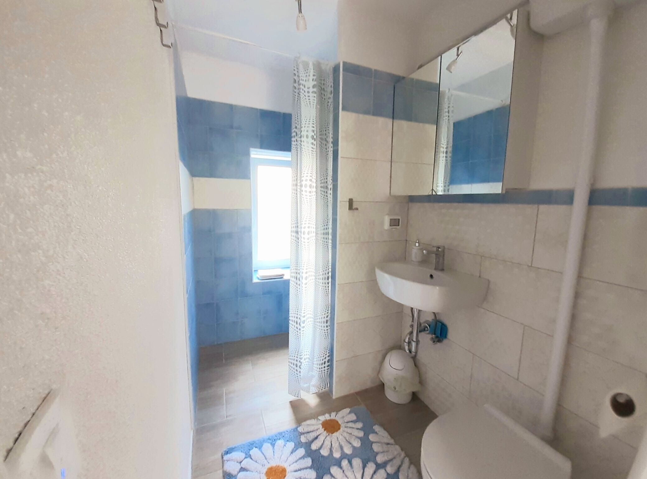 A bathroom with a sink, toilet, and shower area.