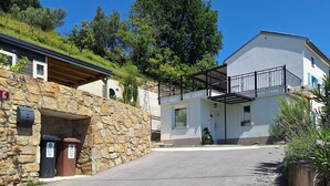 Un bâtiment à deux étages, doté d’une façade en pierre, d’un balcon et surplombant un ciel d’un bleu limpide.