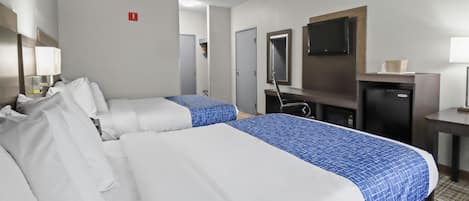 A hotel room with two beds, a desk, a television, and a minibar.