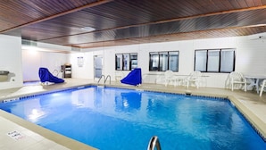 An indoor swimming pool with clear water, wooden ceiling, and white walls. - GrandStay Hotel & Suites  (Minocqua)