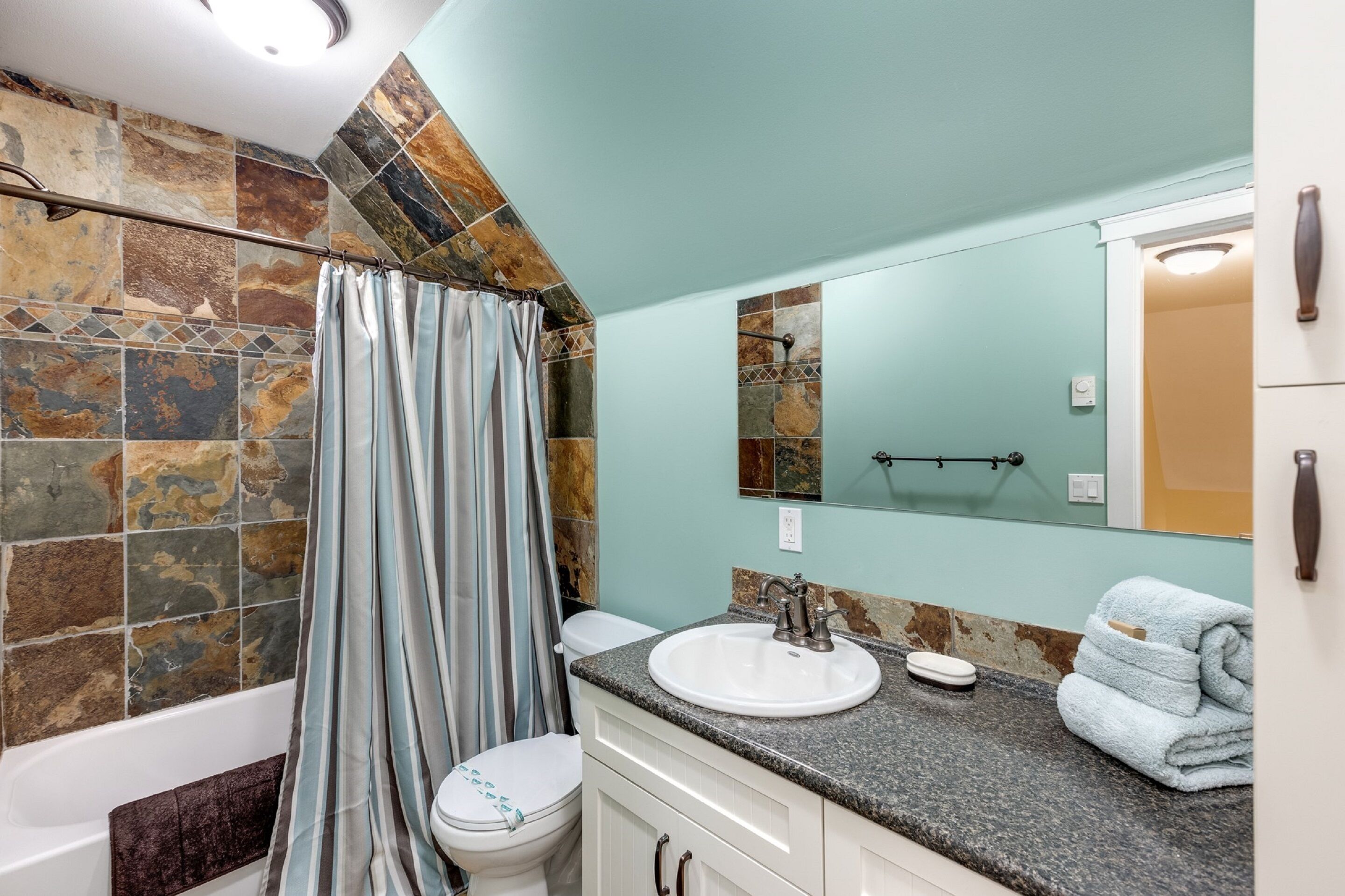 A bathroom with a bathtub, toilet, and sink.