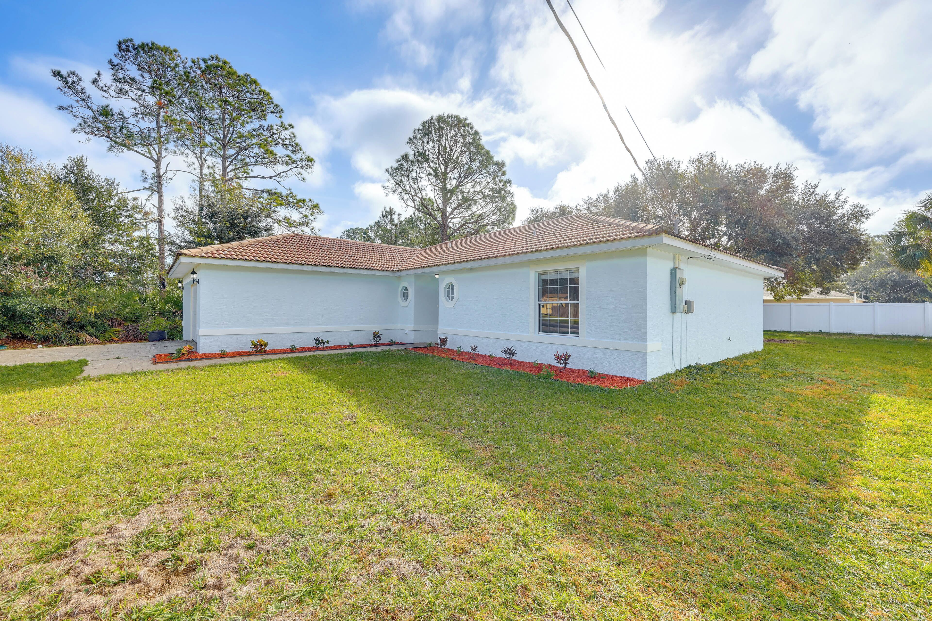 Een gelijkvloers huis met een pannendak, een kleine voortuin en een witte gevel.