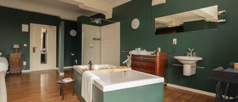 Une salle de bain spacieuse avec une grande baignoire, un lavabo et un miroir.