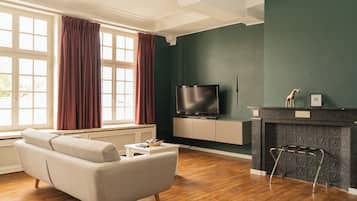 Un salon avec un canapé, une table basse, un téléviseur et une cheminée.