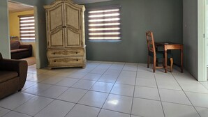 Una habitación amplia con un armario grande, una mesa de comedor con sillas y un sofá.
