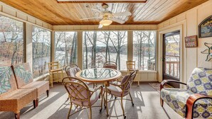 A cozy room with a wooden ceiling, a round glass table, wicker chairs, and a sofa. - Lakefront Hot Springs Village Home w/ Private Dock (Hot Springs)
