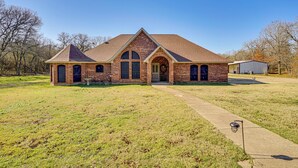 A brick building with a gabled roof, a front entrance, and a small garden area in front. - Large Yard, Fire Pit & Games: Grandview Haven! (Grandview)