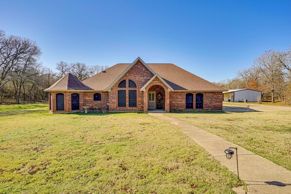 A brick building with a gabled roof, a front entrance, and a small garden area in front. - Large Yard, Fire Pit & Games: Grandview Haven! (Grandview)