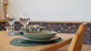 Une table à manger avec une assiette verte, un verre et une fourchette.