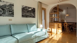 Un salon moderne avec un canapé, un coin repas doté de meubles en bois et une cuisine avec un comptoir en bois.