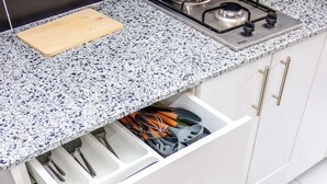 A kitchen with a granite countertop, white cabinets, and a gas stove. - Landmoor Studio Jkia Airport Way (Syokimau)