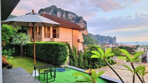 A modern building with a balcony overlooking a lush garden and a mountainous landscape. - B307 - 1 Bedroom Condo Pool View Near Ao Nang Beach (Krabi)