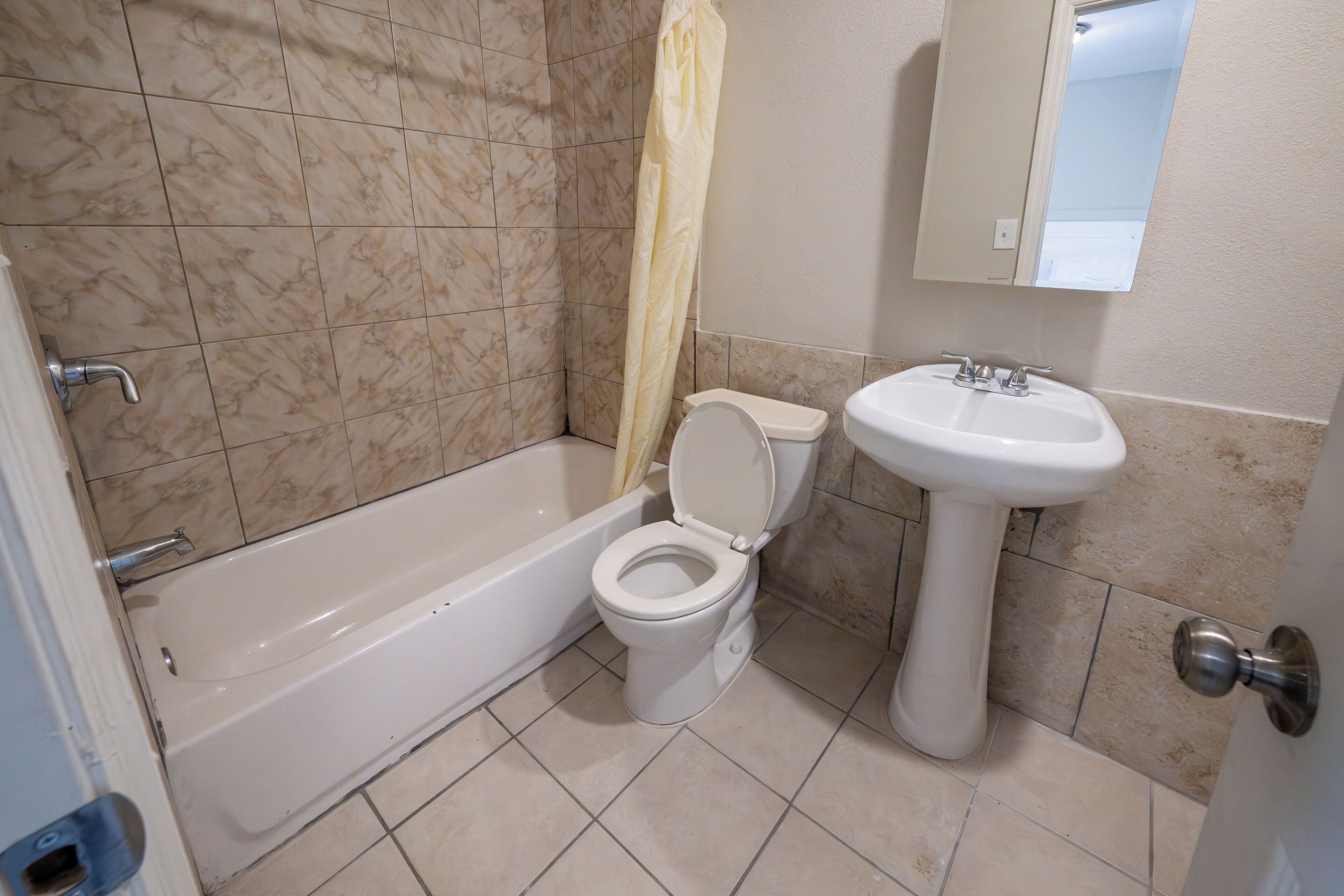 Un bagno con vasca, servizi igienici e lavandino.
