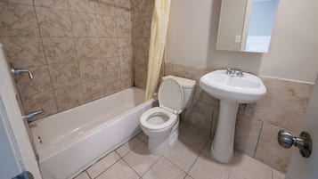 Une salle de bain avec une baignoire, des toilettes et un lavabo.