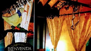 Una habitación con una cama, un cartel que dice "BIENVENIDA" y una ventana con cortinas.
