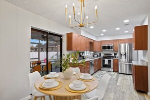 Enjoy meals in the central island kitchen with a round dining table and stainless steel appliances.