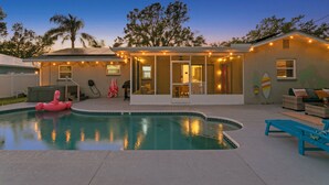 Ein Haus mit Schwimmbad, einem Flamingo-Schwimmpfad und Lichterketten.