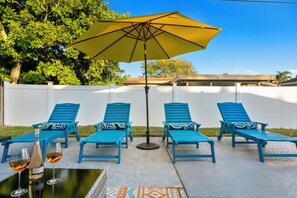 Relax in style with comfortable lounge chairs and a shaded table, perfect for socializing or unwinding.
