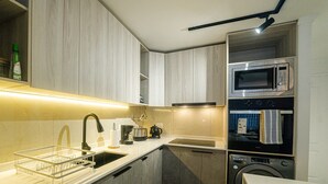 Cozinha moderna com micro-ondas embutido, forno e máquina de lavar louça.