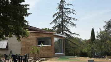 A modern house with a swimming pool, wooden deck, and outdoor furniture.