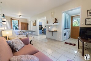Relax in this open-plan living space with a sofa, kitchen area, and access to the outdoor space.