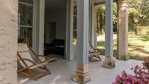 Une véranda avec des fauteuils à bascule en bois et une vue sur l’intérieur.