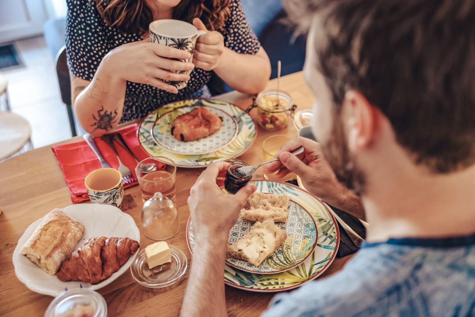 A dining table with plates of food, a cup, and a glass of water.