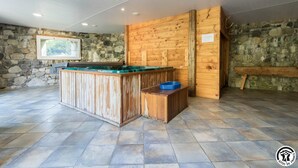 A rustic wooden bar area with a stone wall backdrop, a bench, and a framed picture on the wall. - Benque-Dessus Farm (Benque-Dessous-et-Dessus)