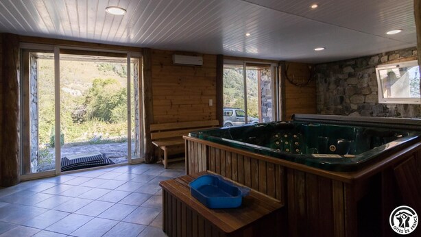 A wooden interior with a hot tub, a bench, and a view of the outdoors. - Benque-Dessus Farm (Benque-Dessous-et-Dessus)