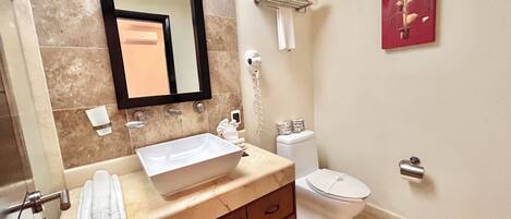A bathroom with a white sink, a mirror, a toilet, and a towel rack.
