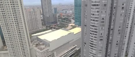 Un edificio alto con varios pisos, ventanas amplias y techo plano.