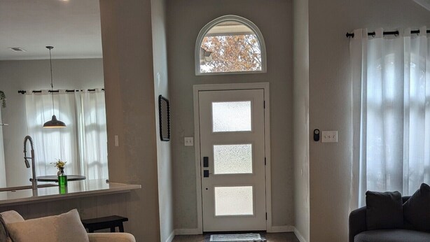 A living room with a sofa, a coffee table, and a dining area with a kitchen counter. - Five star ratings! Pet Friendly! Lovely Rockwall home near The Harbor! ⛴️🐡 (Rockwall)
